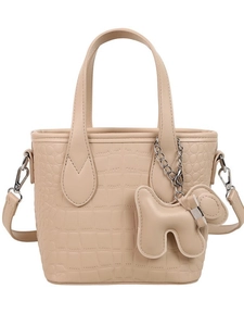 Beige crocodile-embossed tote bag with dual handles and dog charm on white background