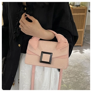 Detail of pink snakeskin pattern bag with large black square buckle and top handle
