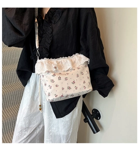 Detail of floral crossbody bag featuring lace trim edges and a matching printed strap