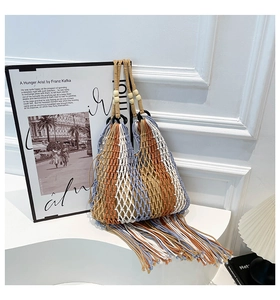 Close-up of bohemian woven tote bag with fringe details and decorative wood beads