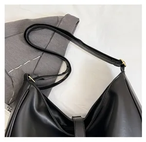 Detail of black matte PU leather Hobo bag featuring wide shoulder strap and gold buckle