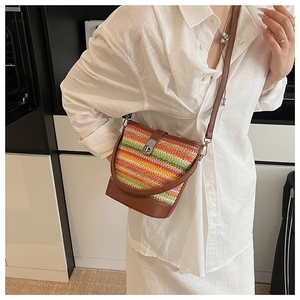 Detailed shot of rainbow woven bucket bag with brown leather strap and metal buckle closure