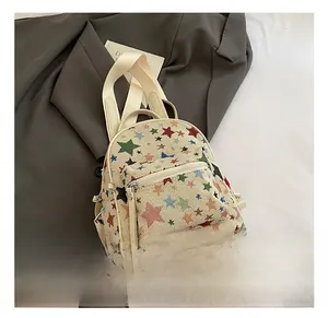 Detail showing colorful star embroidery and front pocket on canvas backpack with zipper
