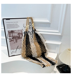Detail of woven mesh tote with wooden beads on handles and long fringe tassels at bottom