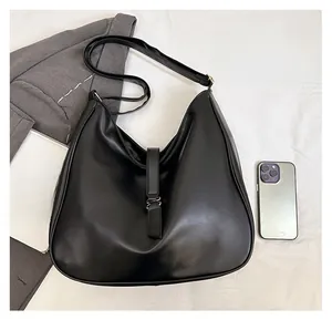 Detail of large black hobo tote bag with silver buckle and adjustable shoulder strap