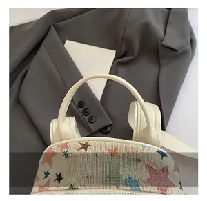 Detail of canvas bag with embroidered colorful stars and comfortable leather handle