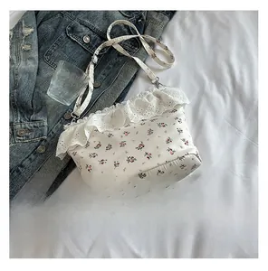 Close-up of white floral tote bag featuring elegant lace trim and adjustable shoulder strap