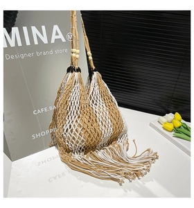 Close-up of woven fringe tote bag with wooden ring handles and bohemian tassels