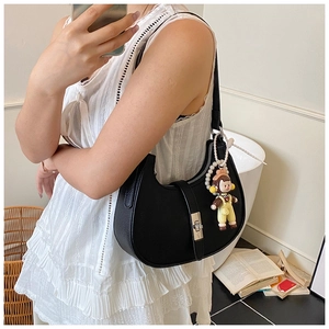 Close-up of black lychee grain crescent hobo bag featuring silver lock and cute charm