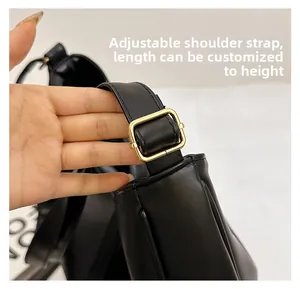 Detail of adjustable shoulder strap with gold buckle on a black tote bag