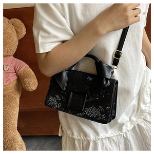 Detail of black snake pattern crossbody bag featuring a large decorative square buckle