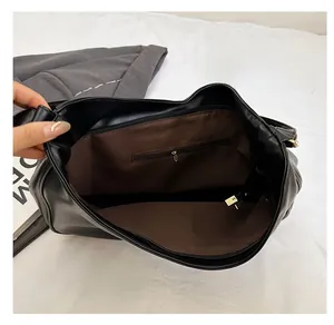 Interior view of large black leather tote bag with brown lining and zipper pocket