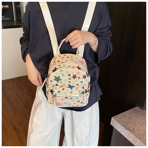 Detail of mini canvas backpack with colorful star embroidery and multiple pockets