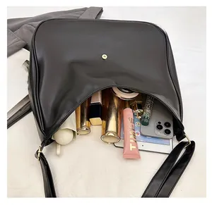 Top view of large black matte hobo bag showing spacious interior with tablet and umbrella