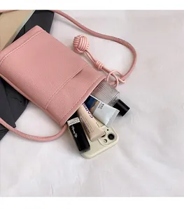 Internal storage of pink litchi leather phone bag showing makeup and compact space