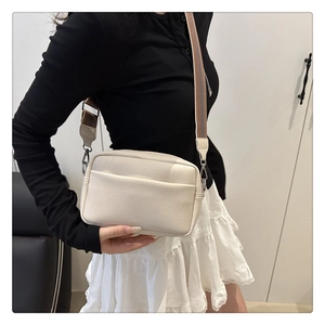 Detail of lychee pattern cream white crossbody bag with striped wide shoulder strap