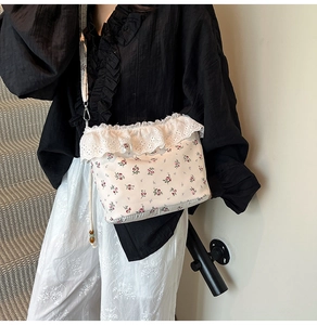 Close-up of floral crossbody bag featuring delicate lace ruffles and drawstring beads