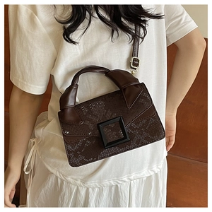 Détails de texture serpent marron foncé et grande boucle mate sur un sac vintage rétro