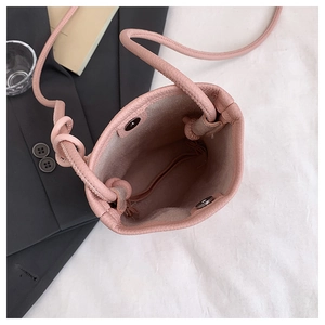 Detail of pink pebbled leather bucket bag showing magnetic closure and interior space