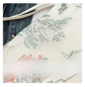 Macro shot of traditional Chinese embroidery featuring willow and pavilion on white organza