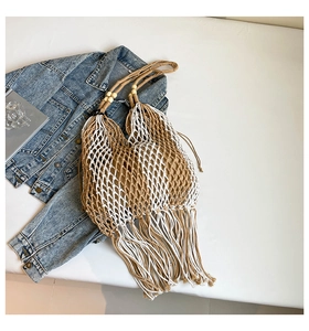 Detail of bohemian woven tote bag with fringe tassels, wooden beads and inner lining