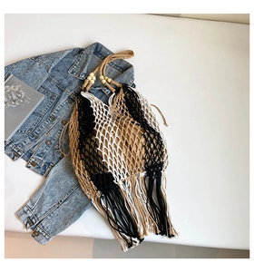Detail of bohemian woven tote bag featuring mesh pattern, wooden beads and long fringe tassels
