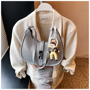 Detail of silver lychee texture bag with adjustable strap and pearl doll charm