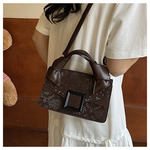 Détail du sac bandoulière marron foncé à motif serpent avec poignée nouée et grande boucle