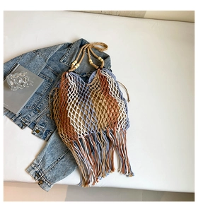 Detail of bohemian handwoven tote featuring multicolor stripes and long fringe accents