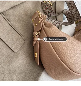 Detail of fine stitching on beige pebble leather hobo bag with woven shoulder strap