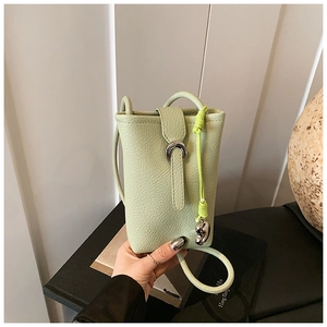 Close-up of pistachio green pebble leather phone bag with silver horseshoe buckle detail
