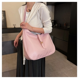 Close-up of pink leather hobo bag with a prominent golden metallic clasp buckle