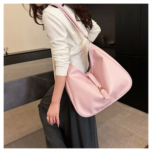 Detail of a pink high-capacity hobo bag with golden metal buckle and smooth fabric texture