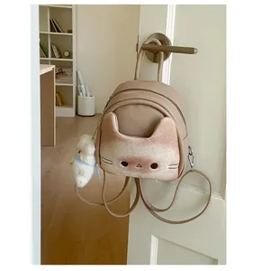 Detail view of cartoon cat backpack with plush ears and a cute white bear pendant charm