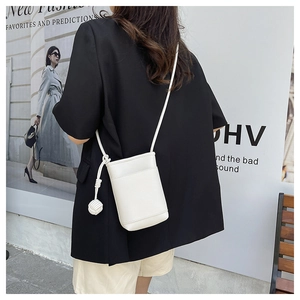 Close-up of white lychee-textured mini crossbody phone bag with knot strap detail