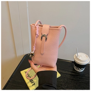 Close-up of pink lychee leather phone bucket bag with silver horseshoe buckle and charm