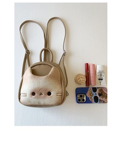 Detail showing internal capacity of the khaki cat-shaped bag with everyday essentials