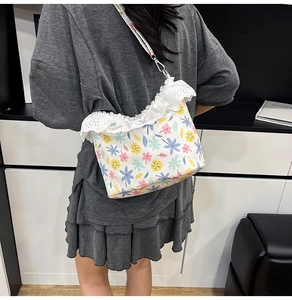 Floral crossbody bag with lace trim and silver hardware details on a lifestyle model
