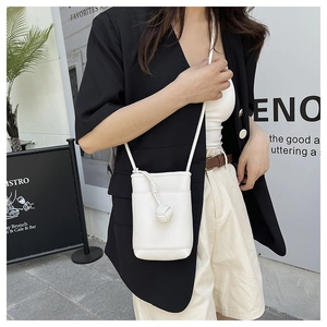 Detail of white lychee texture crossbody mini phone bag with decorative knot ball charm