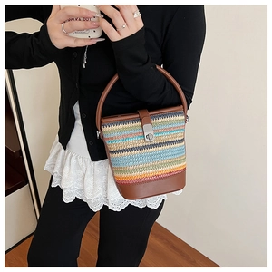 Detail of multi-color rainbow woven bucket bag with leather handle and metal twist lock
