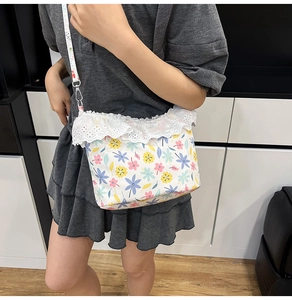 Detailed close-up showing floral pattern and elegant white lace trim on the shoulder bag