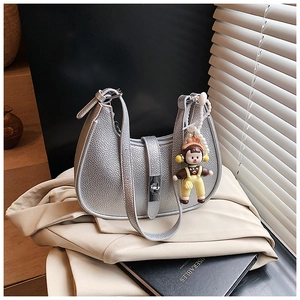 Detail of silver metallic lychee texture handbag with trendy rotating metal lock clasp