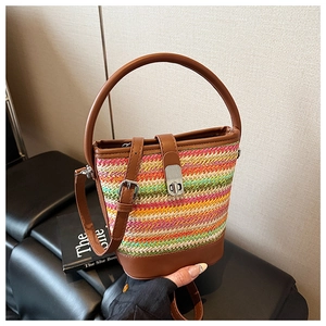 Close-up of rainbow woven bucket bag with brown leather strap and silver metal twist lock