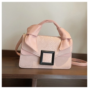 Detail of pink snake-skin pattern textured bag with stylish knotted handle and square buckle