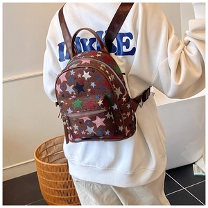 Brown canvas mini backpack with colorful star pattern shown on model's back