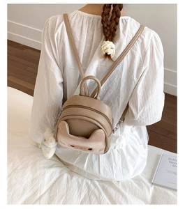 Detailed back view of a cute khaki cat backpack with plush pocket and bear charm
