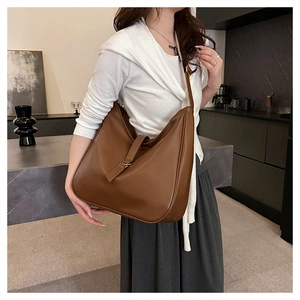Detailed view of caramel brown leather hobo bag showing adjustable strap and matte texture