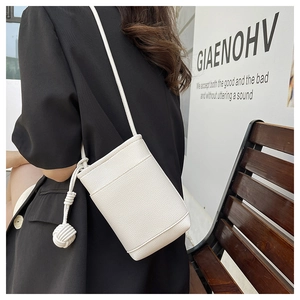 Detail of white pebbled leather mini crossbody bag featuring a unique braided spherical knot