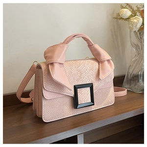 Detail of pink snake-patterned leather bag with knotted handle and black square buckle