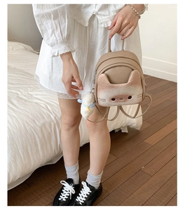 Detail of cute cat shaped backpack with 3D ears and plush ball charm decoration